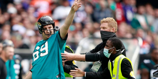 Stewards remove a man who ran onto the pitch before an NFL football game between the Miami Dolphins and the Jacksonville Jaguars at the Tottenham Hotspur stadium in London, England, Sunday, Oct. 17, 2021.