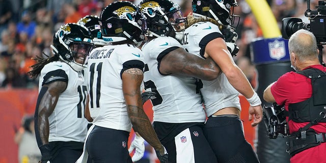 Jacksonville Jaguars quarterback Trevor Lawrence, front, celebrates with teammates after rushing for a touchdown during the first half of an NFL football game against the Cincinnati Bengals, Thursday, Sept. 30, 2021, in Cincinnati. 