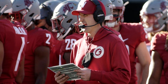 Washington State defensive coordinator and linebackers coach Jake Dickert, center, stands on the field during a break in play in the second half of an NCAA college football game, Saturday, Oct. 9, 2021, in Pullman, Wash. Dickert was named Washington State interim head coach, Monday, Oct. 18 after head coach Nick Rolovich was fired for refusing a state mandate that all employees get vaccinated against COVID-19.