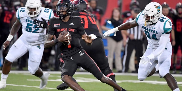Arkansas State quarterback James Blackman (1) tries to get away from Coastal Carolina defenders C.J. Brouer (52) and Jeffrey Gunter (94) during the first half of an NCAA college football game Thursday, Okt.. 7, 2021, in Jonesboro, Ark.