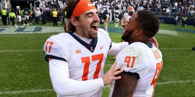 llinois players James McCourt (17) and Jamal Woods (91) celebrate their 20-18 victory over Penn State after the ninth overtime of an NCAA college football game in State College, Pa.on Saturday, Oct. 23, 2021.