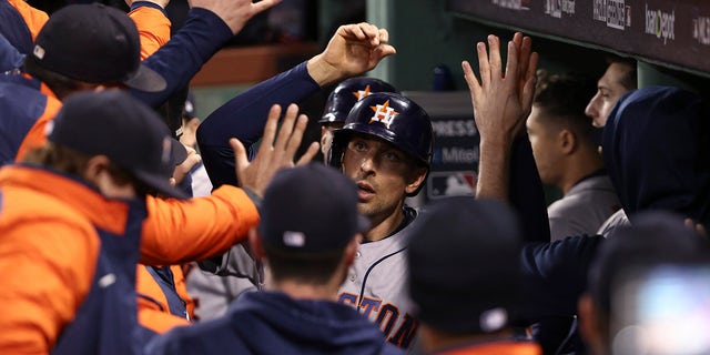 The Houston Astros' Jason Castro celebrates in the dugout after scoring against the Boston Red Sox during the ninth inning of Game 4 of baseball's American League Championship Series Tuesday, Oct. 19, 2021, in Boston.