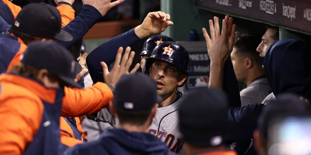 The Houston Astros' Jason Castro celebrates in the dugout after scoring against the Boston Red Sox during the ninth inning of Game 4 of baseball's American League Championship Series Tuesday, Oct. 19, 2021, in Boston.