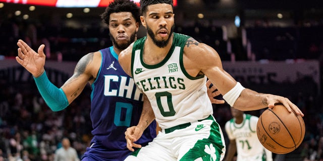 Charlotte Hornets forward Miles Bridges (0) guards against Boston Celtics forward Jayson Tatum (0) during the first half of an NBA basketball game in Charlotte, N.C., Monday, Oct. 25, 2021.