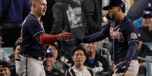 Atlanta Braves' Eddie Rosario, right, is congratulated by Atlanta Braves' Joc Pederson after hitting a two-run home run in the ninth inning against the Los Angeles Dodgers in Game 4 of baseball's National League Championship Series Wednesday, Oct. 20, 2021, in Los Angeles.