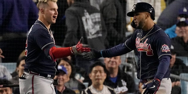 Atlanta Braves' Eddie Rosario, right, is congratulated by Atlanta Braves' Joc Pederson after hitting a two-run home run in the ninth inning against the Los Angeles Dodgers in Game 4 of baseball's National League Championship Series Wednesday, Oct. 20, 2021, in Los Angeles.