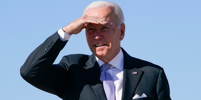 President Joe Biden shields his eyes as he walks toward Air Force One at Andrews Air Force Base in Maryland, on Oct. 20, 2021.