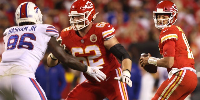 Joe Thuney #62 blocks as Patrick Mahomes #15 of the Kansas City Chiefs looks to pass the ball under pressure from Boogie Basham #96 of the Buffalo Bills during the first half of a game at Arrowhead Stadium on October 10, 2021, in Kansas City, Missouri.