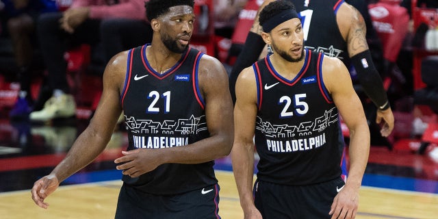 Feb 27, 2021; Philadelphia, Pennsylvania, USA; Philadelphia 76ers guard Ben Simmons (25) and center Joel Embiid (21) look on during the third quarter against the Cleveland Cavaliers at Wells Fargo Center.