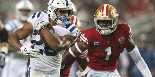Indianapolis Colts running back Jonathan Taylor, links, runs in front of San Francisco 49ers free safety Jimmie Ward (1) during the first half of an NFL football game in Santa Clara, Kalifornië, Sondag, Okt.. 24, 2021.
