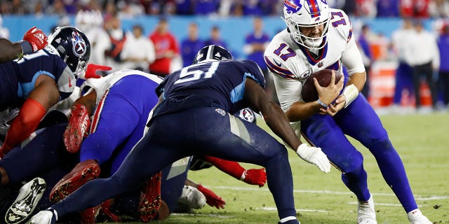 O quarterback do Buffalo Bills, Josh Allen (17), foi interrompido na linha de gol pelo quarterback do Tennessee Titans, David Long Jr. (51), no segundo tempo em 18 de outubro em Nashville, Tenn.