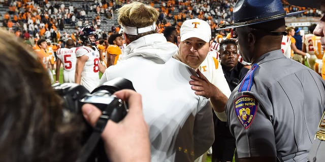 Oct 16, 2021; Knoxville, Tennessee, USA; Tennessee Volunteers head coach Josh Heupel (facing camera) and Mississippi Rebels head coach Lane Kiffin meet at mid field after a game at Neyland Stadium.