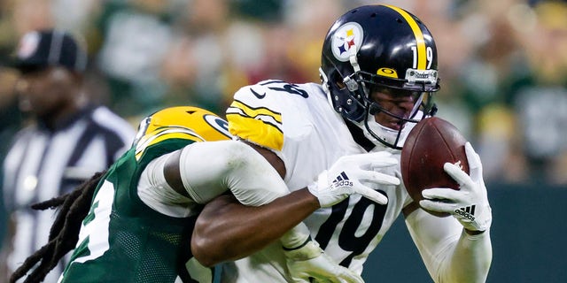 Pittsburgh Steelers 'JuJu Smith-Schuster catches a pass with Green Bay Packers' De'Vondre Campbell defending during the second half of an NFL football game on Sunday, October 3, 2021, in Green Bay, Wisconsin.