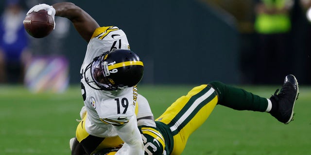 De'Vondre Campbell of the Green Bay Packers prevents JuJu Smith-Schuster of the Pittsburgh Steelers from getting a first down during the second half of an NFL football game on Sunday October 3, 2021 in Green Bay, Wisconsin.