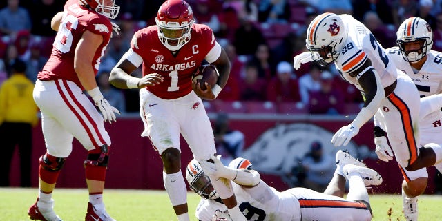 Arkansas quarterback KJ Jefferson (1) slips past Auburn defenders J.J. Pegues (89) and Derick Hall (29) as he runs the ball during the first half of an NCAA football game Saturday, Okt.. 16, 2021, in Fayetteville, Ark.