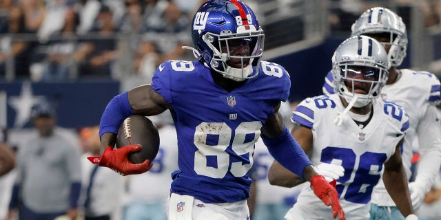 New York Giants wide receiver Kadarius Toney (89) escapes tackle attempts by Dallas Cowboys' Anthony Brown (30) and safety Malik Hooker, bottom right, as Toney gains long yardage after a catch in the first half of an NFL football game in Arlington, Texas, Sunday, Oct. 10, 2021.