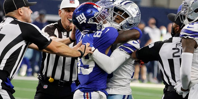 Officials attempt to separate New York Giants' Kadarius Toney (89) and Dallas Cowboys' Damontae Kazee, right, after Toney threw a punch at Kazee in the second half of an NFL football game in Arlington, Texas, Sunday, Oct. 10, 2021.