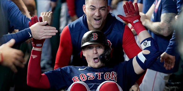 The Boston Red Sox's Enrique Hernández celebrates in the dugout after his home run against the Houston Astros during the fourth inning in Game 2 of the American League Championship Series Saturday, Oct. 16, 2021, in Houston.