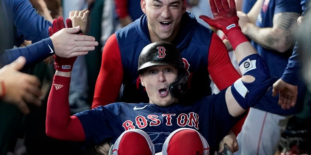 The Boston Red Sox's Enrique Hernández celebrates in the dugout after his home run against the Houston Astros during the fourth inning in Game 2 of the American League Championship Series Saturday, Oct. 16, 2021, in Houston.