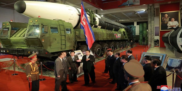 In this photo provided by the North Korean government, North Korean leader Kim Jong Un, center, speaks in front of what the North says an intercontinental ballistic missile displayed at an exhibition of weapons systems in Pyongyang, North Korea, on Monday. 
