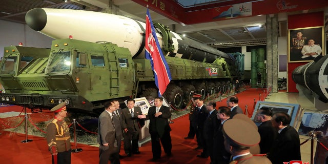 In this photo provided by the North Korean government, North Korean leader Kim Jong Un, center, speaks in front of what the North says an intercontinental ballistic missile displayed at an exhibition of weapons systems in Pyongyang, North Korea, on Monday.