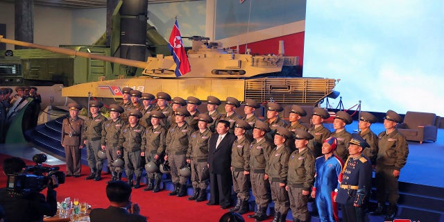 Kim Jong Un, center, poses for a group photo with fighter pilots at the opening of a weapons systems exhibition in Pyongyang, North Korea, on Monday.