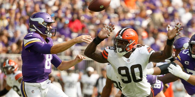 Cleveland Browns defensive end Jadeveon Clowney (90) pressures Minnesota Vikings quarterback Kirk Cousins (8) as he throws a pass during the first half of an NFL football game, Sunday, Oct. 3, 2021, in Minneapolis.