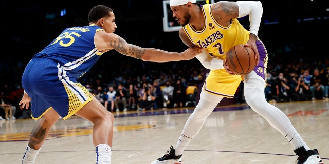 Los Angeles Lakers forward Carmelo Anthony (7) is defended by Golden State Warriors forward Juan Toscano-Anderson (95) during the first half of an NBA basketball game in Los Angeles, Tuesday, Oct. 19, 2021.