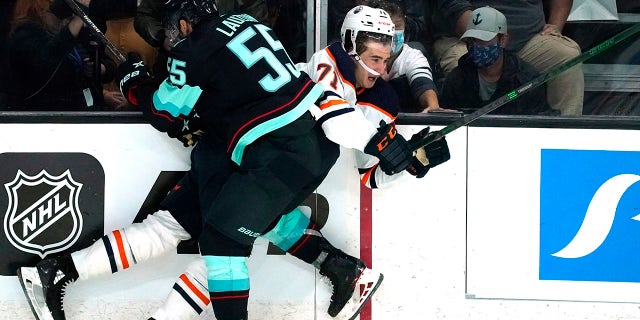 Seattle Kraken's Jeremy Lauzon (55) collides with Edmonton Oilers' Ryan McLeod in the third period of a preseason NHL hockey game Friday, Oct. 1, 2021, in Everett, Wash.