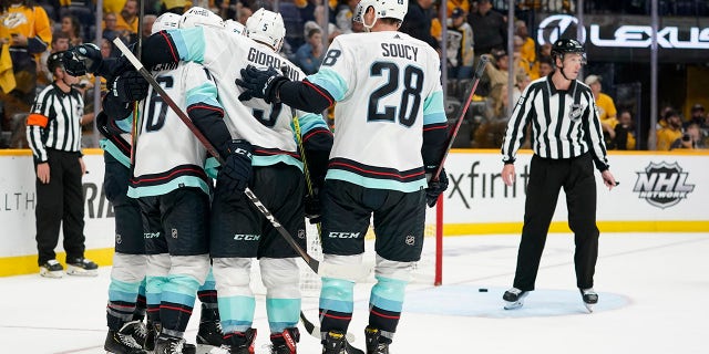 Seattle Kraken celebrate after scoring an empty-net goal against the Nashville Predators in the third period of an NHL hockey game Thursday, Oct. 14, 2021, in Nashville, Tenn. The Kraken won 4-3 for their first franchise win.