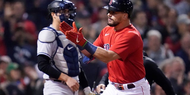 Boston Red Sox Kyle Schwarber celebrates his solo homerun in front of New York Yankees wide receiver Kyle Higashioka in the third inning of an American League Wild Cards playoff baseball game against the New York Yankees at Fenway Park, Tuesday, October 5, 2021, in Boston.