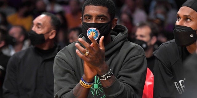 Kyrie Irving of the Brooklyn Nets cheers from the bench during a preseason game against the Los Angeles Lakers at Staples Center on Oct. 3, 2021 in Los Angeles, California.