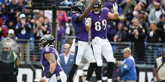 Kết thúc chặt chẽ của Baltimore Ravens Mark Andrews (89 tuổi) ăn mừng với tiền vệ Lamar Jackson, trung tâm, sau khi họ liên lạc với một đường chuyền chạm trán với Los Angeles Chargers vào ngày 17 tháng 10 ở Baltimore.