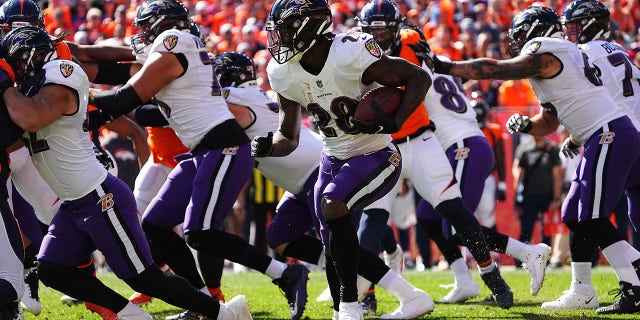 Oct 3, 2021; Denver, Colorado, USA; Baltimore Ravens running back Latavius Murray (28) carries the ball in the first quarter against the Denver Broncos at Empower Field at Mile High.
