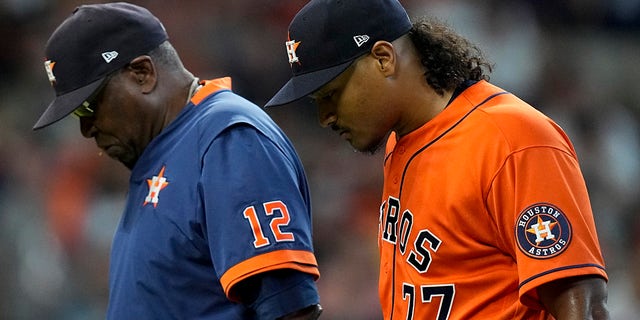 Houston Astros starting pitcher Luis Garcia leaves the game with manager Dusty Baker Jr. during the second inning in Game 2 of the American League Championship Series Saturday, Oct. 16, 2021, in Houston.