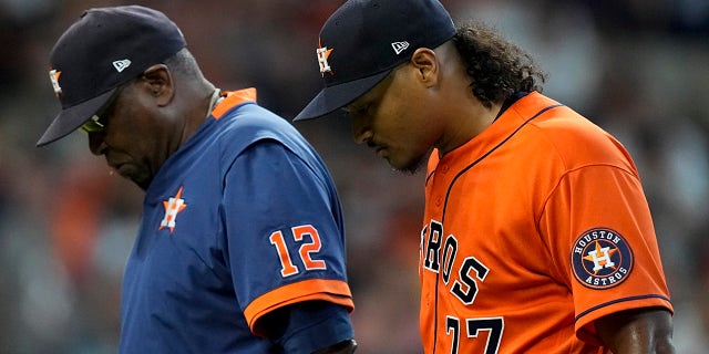 Houston Astros starting pitcher Luis Garcia leaves the game with manager Dusty Baker Jr. during the second inning in Game 2 of the American League Championship Series Saturday, Oct. 16, 2021, in Houston.