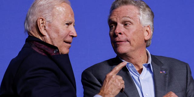 President Biden and Democratic candidate for governor of Virginia Terry McAuliffe interact onstage at a rally in Arlington, Va., Oct. 26, 2021.