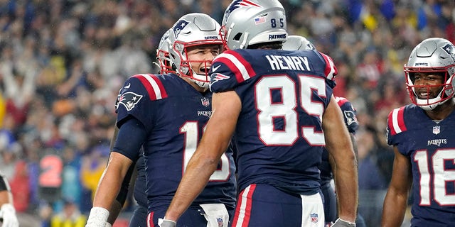 New England Patriots quarterback Mac Jones, left, celebrates after his touchdown pass to tight end Hunter Henry (85) during the first half of an NFL football game against the Tampa Bay Buccaneers on Sunday, October 3, 2021, in Foxborough, Mass.