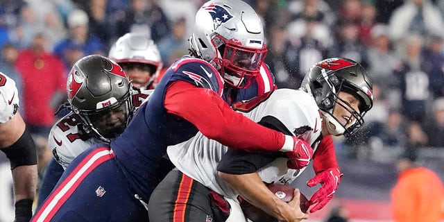 Tampa Bay Buccaneers quarterback Tom Brady, right, is sacked by New England Patriots outside linebacker Matt Judon, left, during the first half of an NFL football game, Sunday, Oct. 3, 2021, in Foxborough, Mass. ()
