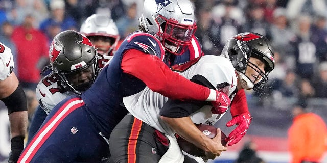 Tampa Bay Buccaneers quarterback Tom Brady, right, is sacked by New England Patriots outside linebacker Matt Judon, left, during the first half of an NFL football game, Sunday, Oct. 3, 2021, in Foxborough, Mass. ()
