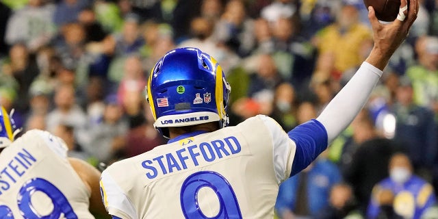 Los Angeles Rams quarterback Matthew Stafford (9) passes a tape on his fingers during the second half of the NFL football game on Thursday, October 7, 2021, in Seattle, Seattle.