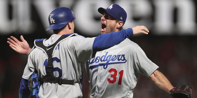 Los Angeles Dodgers catcher Will Smith, left, celebrates with pitcher Max Scherzer (31) after defeating the San Francisco Giants in Game 5 of a baseball National League Division Series on Thursday, October 14, 2021 in San Francisco.