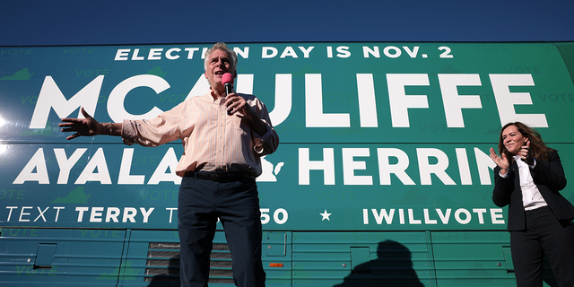 Democratic gubernatorial candidate, former Virginia Gov. Terry McAuliffe, accompanied by his wife Dorothy, speaks to supporters while campaigning on a bus tour at the Iron Workers Local Union 79 October 30, 2021 in Norfolk, Virginia. The Virginia gubernatorial election, pitting McAuliffe against Republican candidate Glenn Youngkin, is November 2