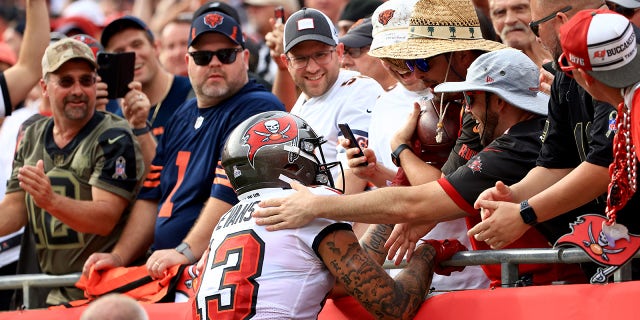 TAMPA, FLORIDA - OCTOBER 24: Mike Evans #13 of the Tampa Bay Buccaneers celebrates with fans after scoring a touchdown in the first quarter against the Chicago Bears in the game at Raymond James Stadium on October 24, 2021 in Tampa, Florida.