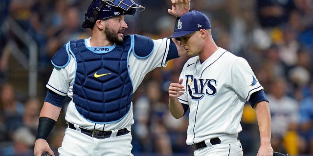Tampa Bay Rays catcher Mike Zunino, left, gives starting pitcher Shane McClanahan a pat on the head after the top of the second inning against the Boston Red Sox in Game 1 of a baseball American League Division Series on Thursday, Oct. 7, 2021, in St. Petersburg, Fla.