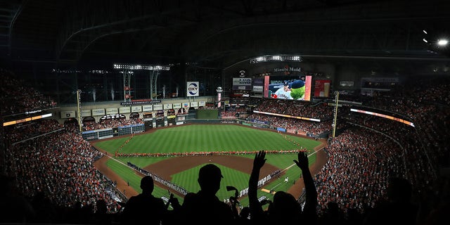 Fans cheer as the Houston Astros and the Atlanta Braves line up for the national anthem prior to the first pitch of Game One of the World Series at Minute Maid Park on Oct. 26, 2021, in Houston. 