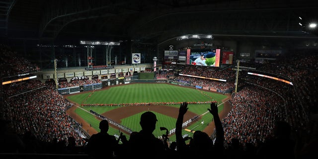 Fans cheer as the Houston Astros and the Atlanta Braves line up for the national anthem prior to the first pitch of Game One of the World Series at Minute Maid Park on Oct. 26, 2021, in Houston. 