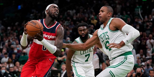 Washington Wizards center Montrezl Harrell, left, drives to the basket against Boston Celtics center Al Horford (42) during the second half of an NBA basketball game, Wednesday, Oct. 27. 2021 in Boston.