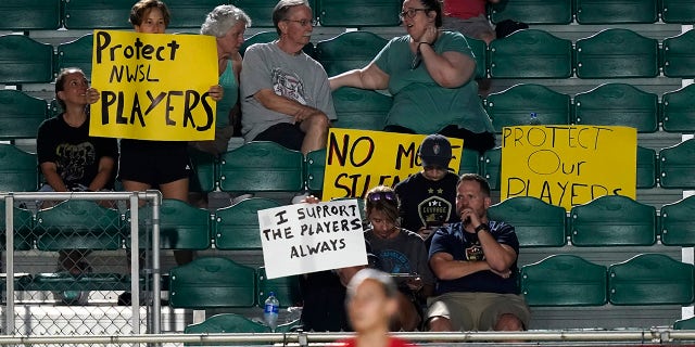 Fans watch during the first half of an NWSL soccer match between the North Carolina Courage and Racing Louisville FC in Cary, N.C., Wednesday, Oct. 6, 2021.