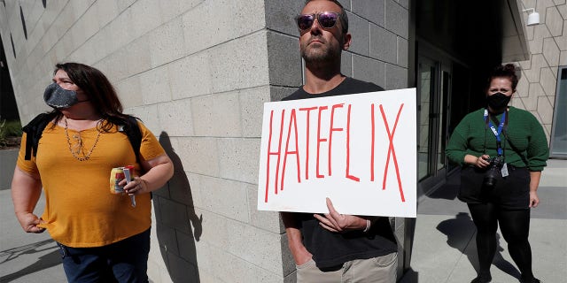 Dave Briggs holds a placard as he attends a rally in support of the Netflix transgender employee walkout ‘Stand Up in Solidarity’ to protest the streaming of comedian Dave Chappelle's new comedy special, in Los Angeles, California, U.S. October 20 2021.